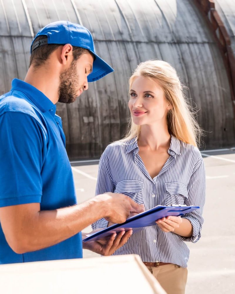 courier-giving-delivery-document-to-beautiful-woman-1.jpg